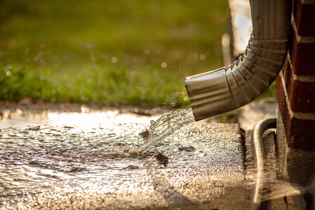 closeup,of,residential,home,gutter,downspout,gushing,out,water,during